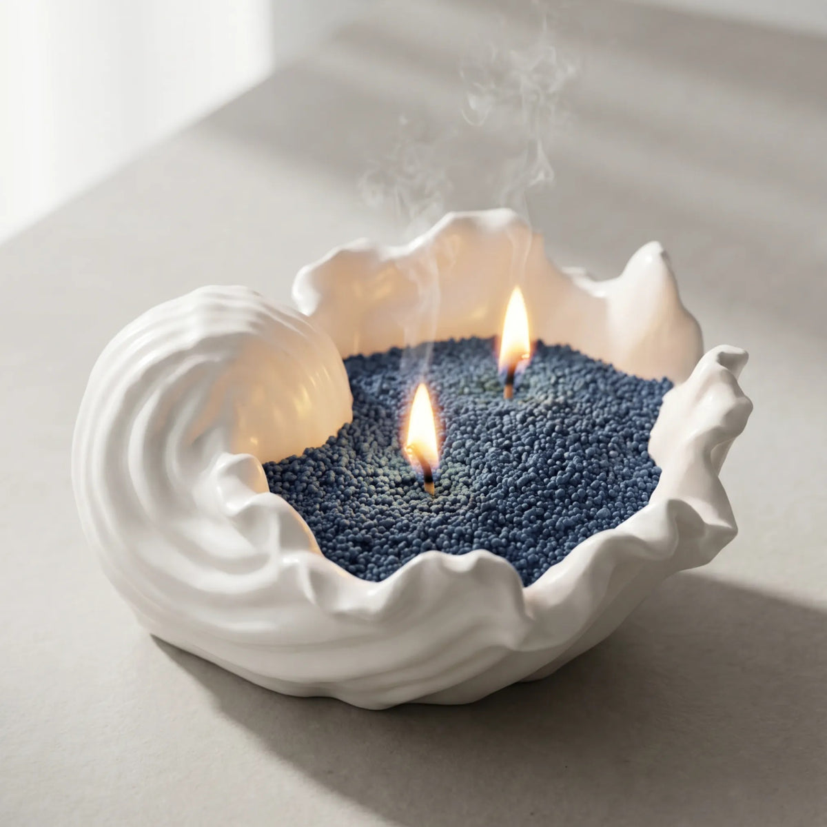 Artistic vase filled with Space Grey pearled candle sand and lit cotton wicks resting on a refined marble countertop