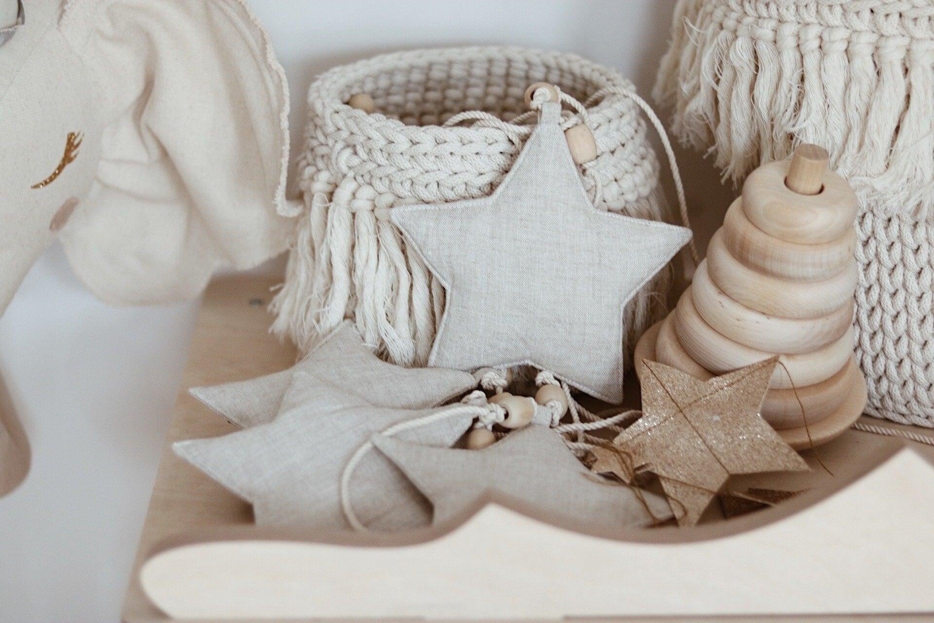 Close-up of the shimmering Sand Star Dust fabric stars resting on a smooth wooden stacking toy