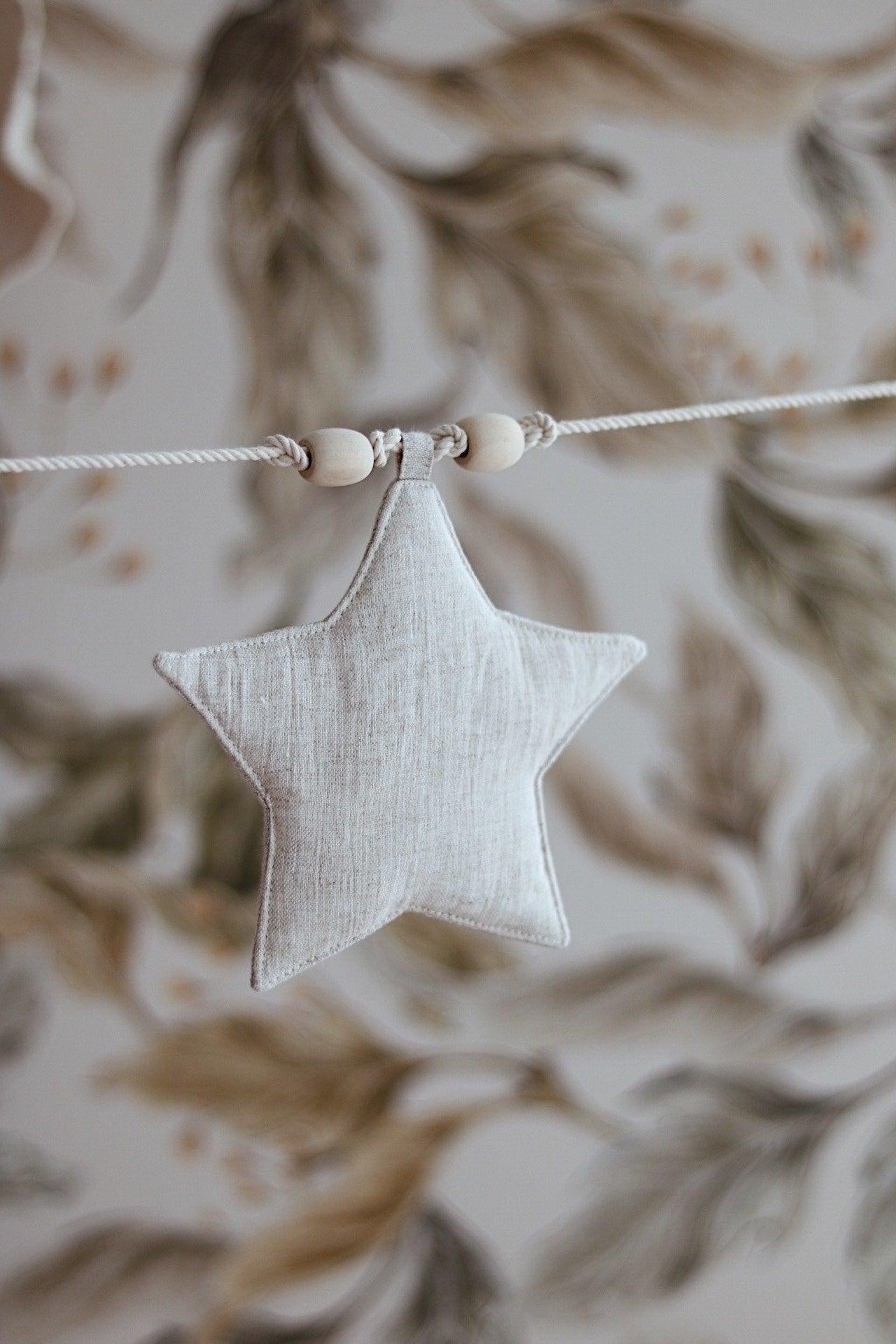 Detailed view of the sand-colored star-shaped fabric discs with sparkling star dust finish