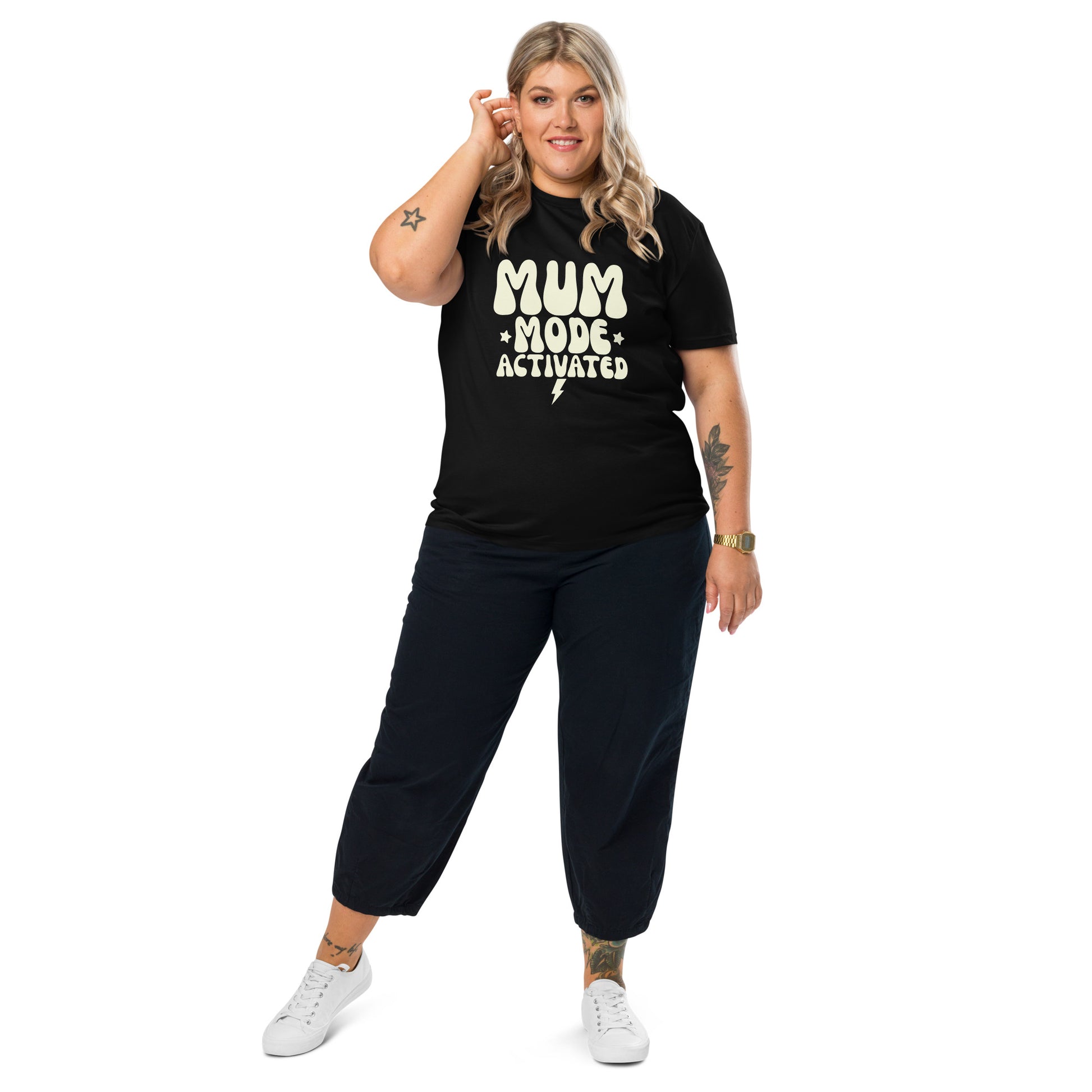 Complete view of Woman wearing a black organic cotton t-shirt with the vintage cream MUM MODE ACTIVATED graphic, looking confident.