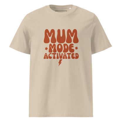 Sand-colored organic cotton t-shirt featuring the quote MUM MODE ACTIVATED in a stacked, retro terracotta font with small stars and a lightning bolt