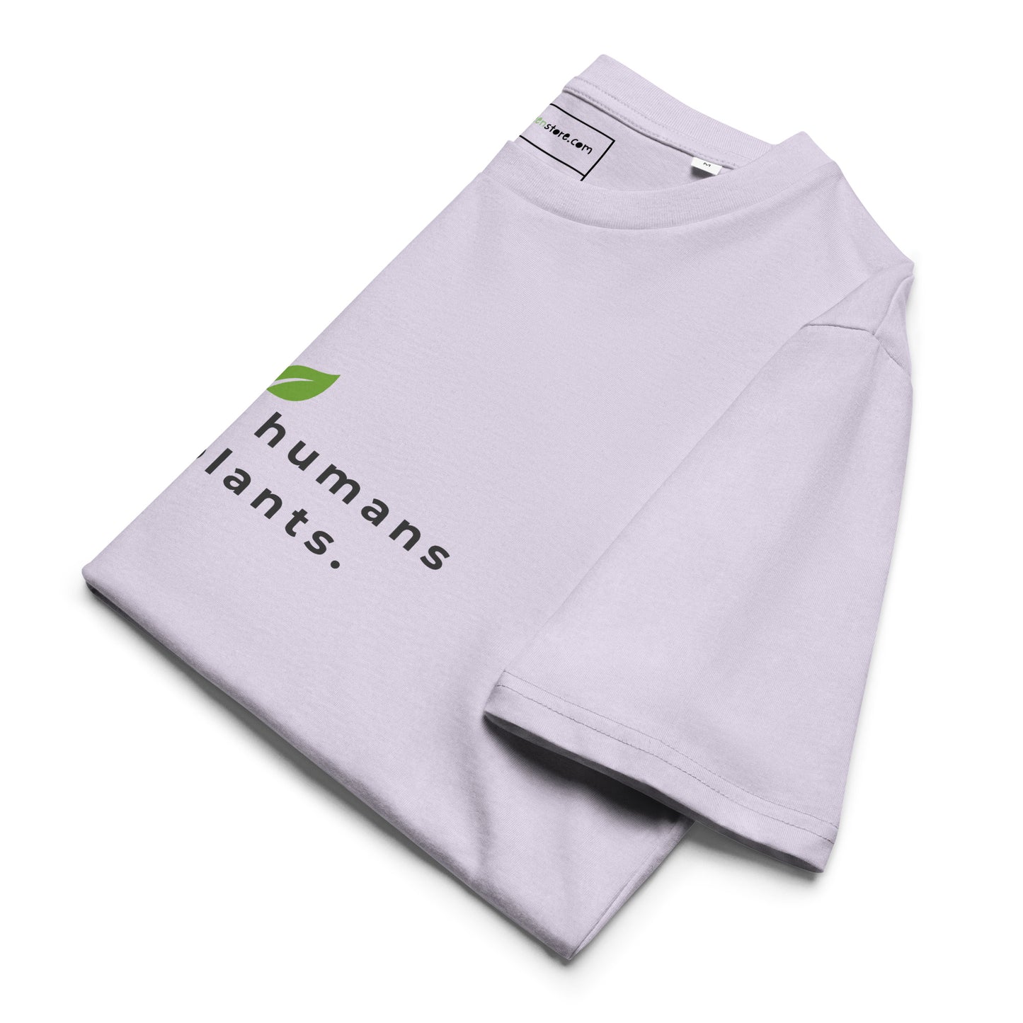 Sustainable t-shirt neatly folded on a flat surface. The top of the folded fabric displays the leaf logo and the "raising humans on plants." message designed for plant-based parents. -lavander-