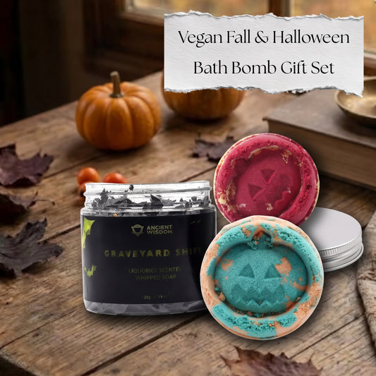 Vegan Fall and Halloween Gift Set featuring a dark whipped soap jar and two pumpkin-faced bath bombs in red and teal on a cozy autumn table