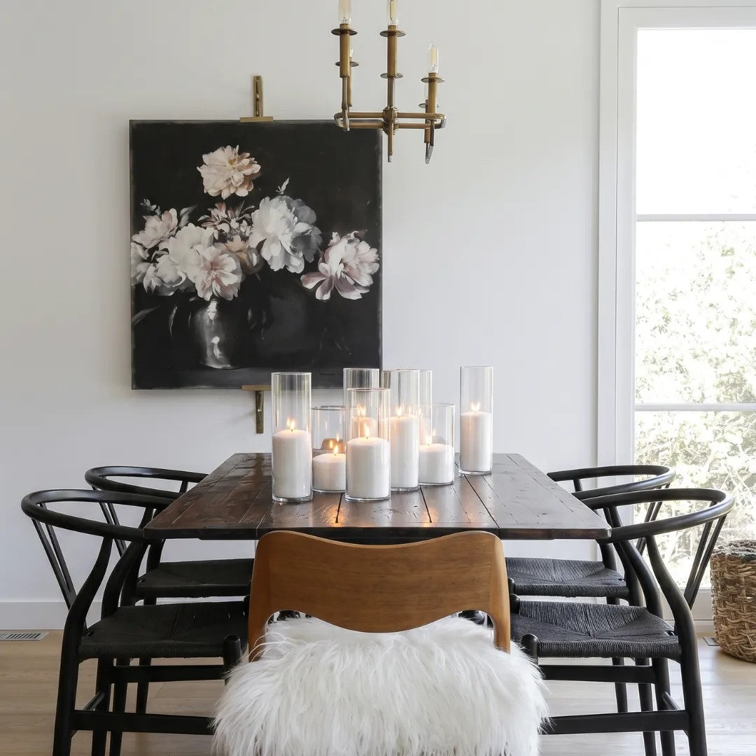 Multiple glowing Candledust pearled sand candles in glass holders arranged on a dark wood table