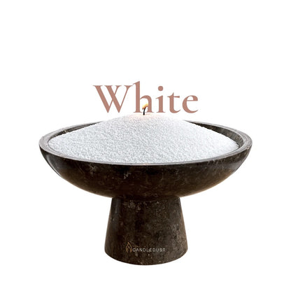 White text on a matching clean white background with a glass vase full of unlit pearled candle sand in the foreground